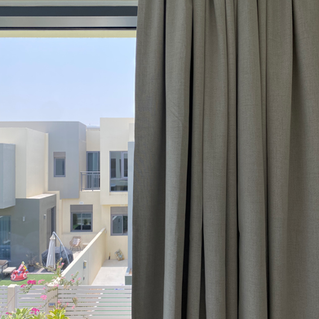 Grey curtains beside a bright window
